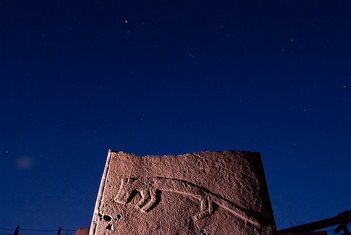 ©Nico Becker. A pillar with a low-relief carving at night